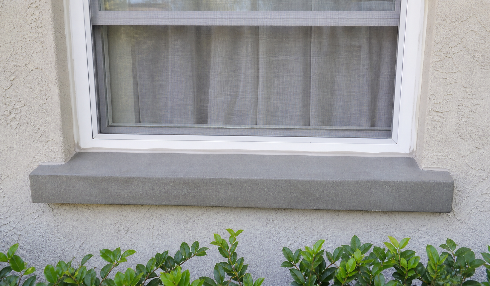 Smooth newly restored concrete sill beneath a Florida home window